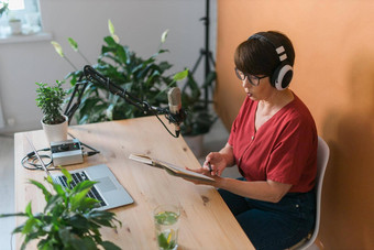 肖像成熟的女人穿耳机会说话的在线<strong>广播站</strong>播客广播概念