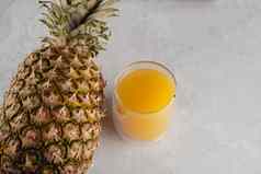 菠萝水果汁双玻璃杯白色石头背景倒黄色的热带水果汁玻璃