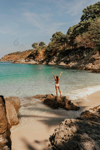 欧洲女人比基尼泳衣站向后石头岩石海洋海岸