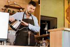 英俊的咖啡师倒热水aeropress咖啡咖啡馆有胡子的咖啡师作品替代使咖啡师咖啡馆