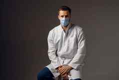 医生医疗面具保护科维德建议保护健康波冠状病毒英俊的男人。穿医疗袍