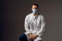 医生医疗面具保护科维德建议保护健康波冠状病毒英俊的男人。穿医疗袍