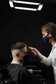 理发店客户医疗面具保护冠状病毒科维德使发型英俊的男人。