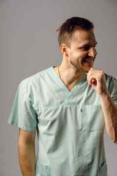 外科医生穿医疗袍微笑摆姿势白色背景英俊的快乐医生摆姿势工作室