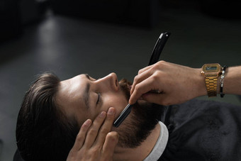 直剃须刀减<strong>少男</strong>人胡子理发店理发师男人。使发型英俊的男人。