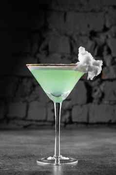 绿色酒精鸡尾酒玻璃装饰棉花糖果灰色的背景