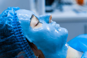 藻酸盐保湿面具脸皮肤年轻的女孩水疗中心过程复兴美容师<strong>涂片</strong>蓝色的面具皮肤病学医疗诊所
