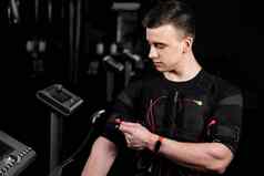 英俊的教练埃姆斯西装红色的电线电冲动刺激身体培训健身房