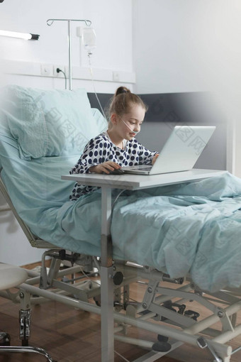 快乐生病了孩子享受视频游戏移动PC休息医院床上