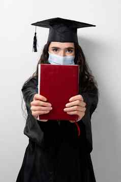 学生书毕业袍帽医疗面具冠状病毒科维德期未来领袖科学院士年轻的女人黑色的礼服微笑