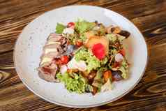 沙拉切片肉奶酪蔬菜混合生菜白色板木表格开胃的餐厅菜