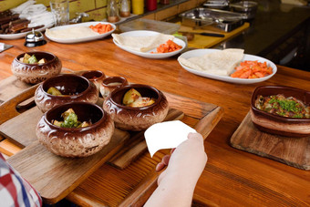 烤土豆陶瓷锅酱汁奶酪木董事会背景餐厅厨房烹饪服务员需要准备菜厨房