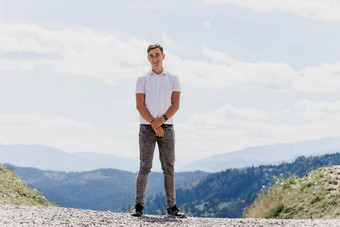 英俊的男人。走绿色山背景广告旅行机构旅游旅行山