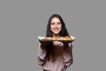 <strong>女孩快递</strong>平萨罗马美食意大利厨房灰色背景持有scrocchiarella传统的菜食物交付比萨 店平萨肉芝麻菜橄榄奶酪