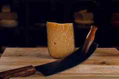 帕尔玛硬岁的奶酪荷兰奶酪刀黑暗背景零食美味的一块奶酪开胃菜