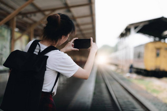 旅游女人艾琳自拍智能手机火车站享受旅行概念女孩智能手机铁路站平台