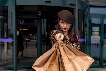 快乐购物狂女孩袋购物中心女人商店快乐购买持有袋穿着豹打印衣服消费者概念