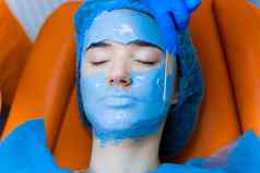 藻酸盐保湿面具脸皮肤年轻的女孩水疗中心过程复兴美容师涂片蓝色的面具皮肤病学医疗诊所
