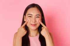 美时尚生活方式概念特写镜头愚蠢的可爱的可爱的亚洲女孩戳脸颊微笑幸福的促销护肤品化妆产品粉红色的背景