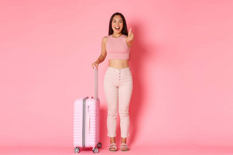 旅行假期假期概念快乐的微笑有吸引力的亚洲女孩夏天衣服包装<strong>旅程</strong>显示竖起大拇指批准推荐旅行机构持有手提箱