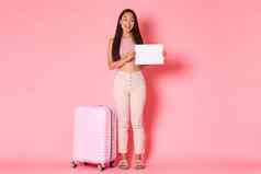 旅行假期假期概念全身的卖弄风情的时尚的浅黑肤色的女人亚洲女孩等待选择机场站标志手提箱粉红色的背景
