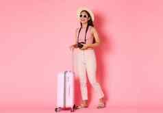 旅游夏天假期假期在国外概念完整的长度无忧无虑的亚洲女孩旅游旅行者享受夏天度假胜地携带手提箱粉红色的背景采取图片相机