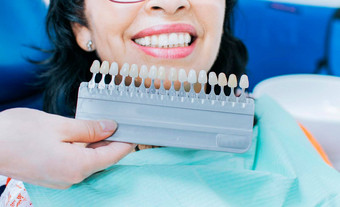 cosmetological牙齿美白牙科诊所选择<strong>语气</strong>植入物牙女人持有集植入物阴影<strong>语气</strong>微笑年轻的女人