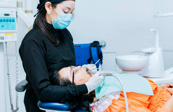 口腔学家清洁病人的牙齿牙医清洁病人的口牙医清洁病人的龋齿牙医清洁病人的口