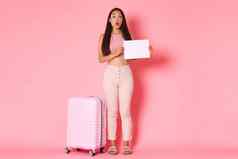 旅行假期假期概念全身的逗乐着迷亚洲美丽的女孩旅游站一块纸标志粉红色的背景手提箱