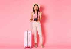 旅游夏天假期假期在国外概念完整的长度美丽的微笑女孩旅行者他旅游相机手提箱显示竖起大拇指推荐酒店目的地