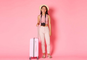旅游夏天假期假期在国外概念完整的长度美丽的微笑女孩旅行者他旅游相机手提箱准备好了冒险站粉红色的背景