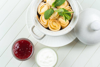 美丽的服务塞煎饼白色<strong>陶瓷锅</strong>树莓小时酸奶油新装的薄荷白色背景不错的早餐甜点视图