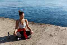 高角拍摄美丽的放松女人瑜伽培训海冥想码头