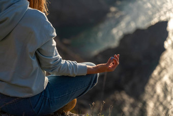 女人旅游享受日落海山景观坐在在户外岩石海穿牛仔裤蓝色的连帽衫<strong>健康</strong>的生活方式<strong>和谐</strong>冥想