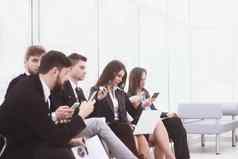 业务团队笔记本电脑智能手机坐着办公室游说团体互联网生活方式一代