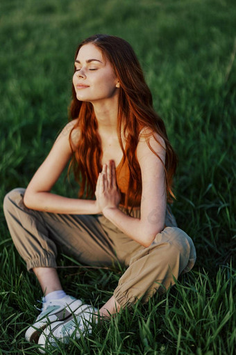年轻的女人夏天衣服坐着绿色草瑜伽冥想自然连接宇宙概念和谐身体自然精神上的增长