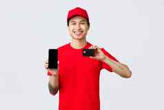交付应用程序在线购物航运概念友好的微笑亚洲快递红色的统一的帽t恤推荐应用程序显示智能手机信贷卡
