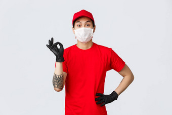 好有魅力的亚洲交付的家伙红色的t恤帽保证客户端包安全员工穿医疗面具保护手套流感大流行科维德显示确认标志