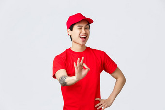 交易市场英俊的微笑亚洲交付的家伙红色的帽t恤确保质量交付货物安全包裹快递显示批准标志眨眼厚颜无耻的相机