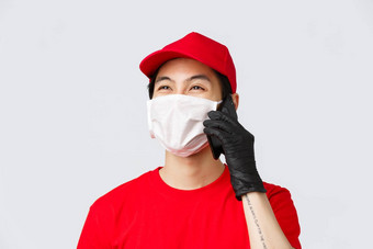 科维德self-quarantine在线购物交付概念友好的年轻的亚洲快递医疗面具保护手套调用客户端回答客户来电微笑灰色背景