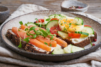 斯莫雷布罗德传统的丹麦三明治黑色的黑麦面包大马哈鱼奶油奶酪黄瓜西红柿木表格一边视图
