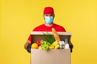 外卖交付科维德检疫食品杂货概念脾气暴躁的快递医疗面具红色的统一的带客户食物盒子订单站黄色的背景