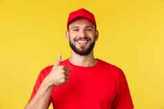 特写镜头快乐的乐观有胡子的员工快递红色的统一的显示竖起大拇指鼓励客户订单提供质量服务保证支持黄色的背景