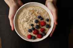 板粥手黑暗背景前视图健康的早餐树莓
