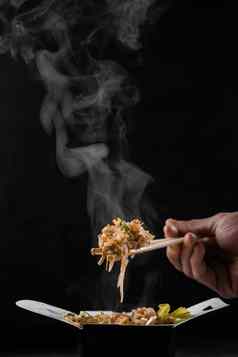 热气腾腾的热大米锅盒子黑色的背景持有大米中国人筷子亚洲辣的菜街餐厅快食物交付服务