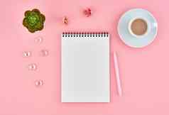 空白记事本白色页面杯可可粉红色的桌子上颜色背景前视图平躺