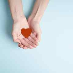 人持有红色的心手捐赠家庭保险概念海蓝宝石背景