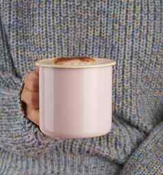 手持有杯热巧克力灰色的舒适的毛衣美丽的粉红色的修指甲首页风格秋天早....关闭