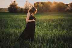 怀孕了女孩黑色的长衣服走绿色高草