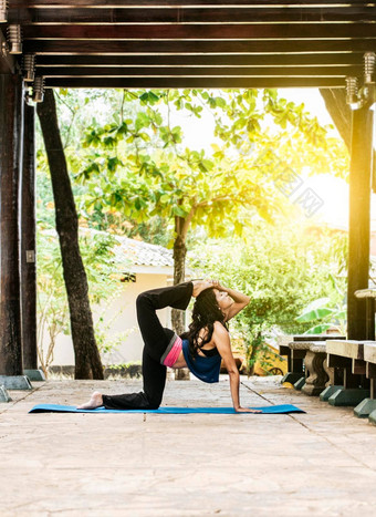 女孩瑜伽股四头肌伸展运动健身女人股四头肌瑜伽在户外伸展运动瑜伽概念